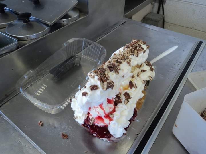 A banana split with whipped cream, chocolate and strawberry at the window