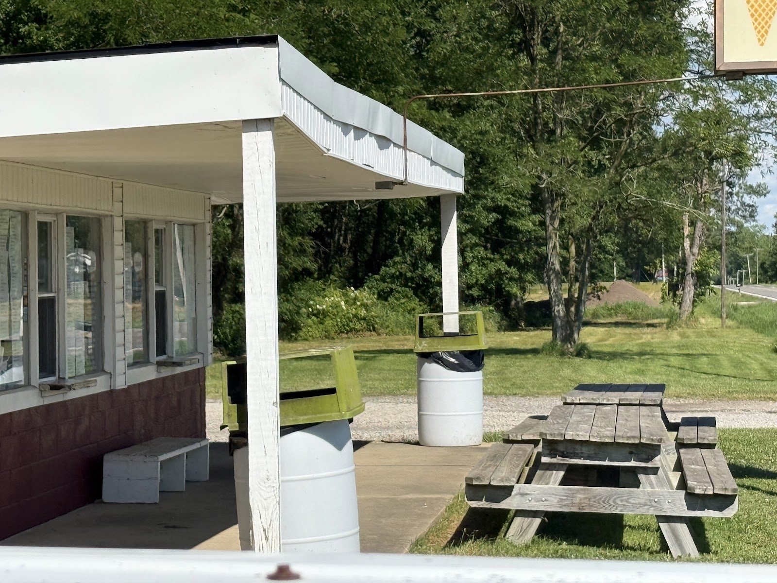 The white and red North Benton Dairy Bar stand with picnic tables out front